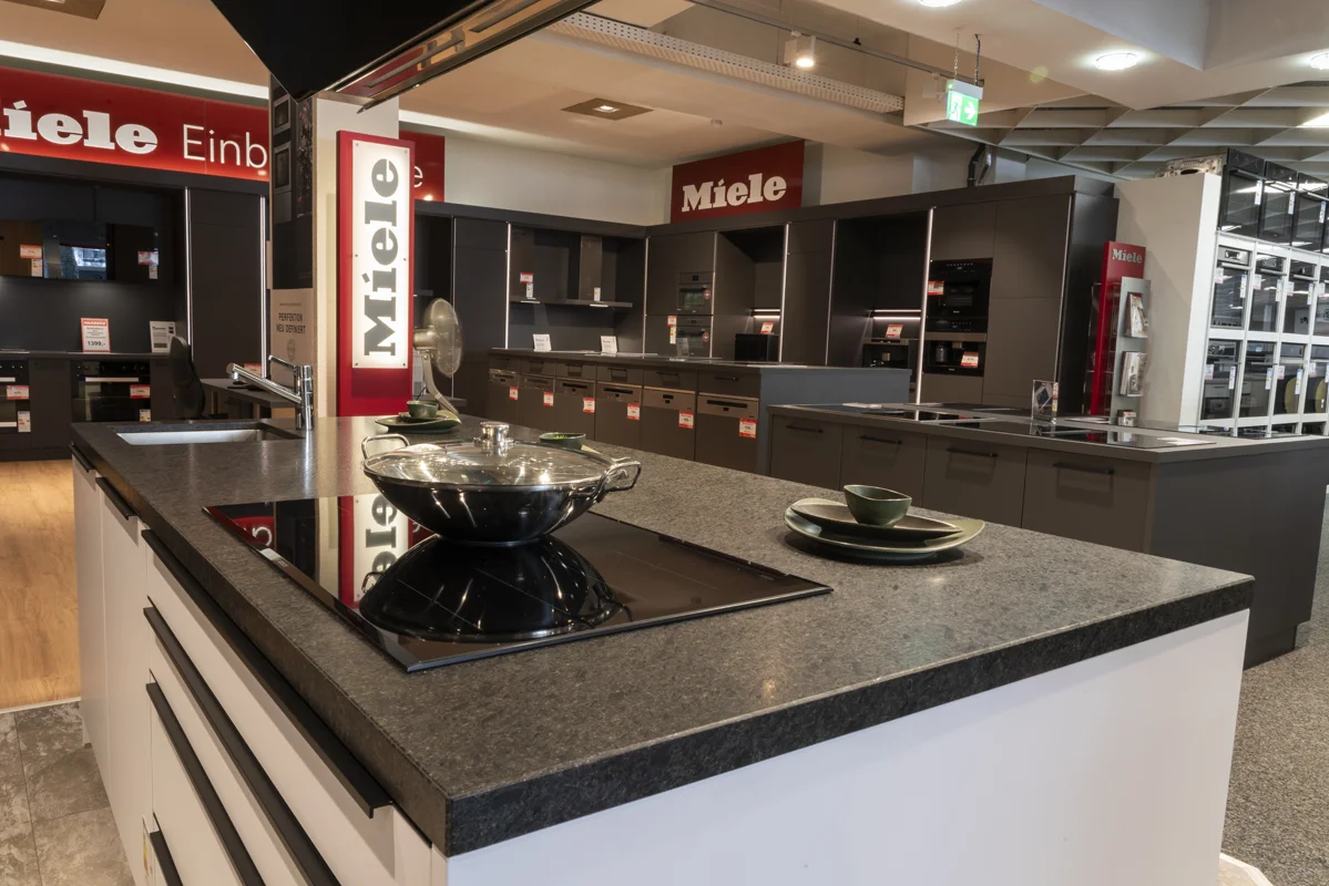 Harbeke • Moderne Miele-Küchenausstellung mit Kochfeld und Topf.