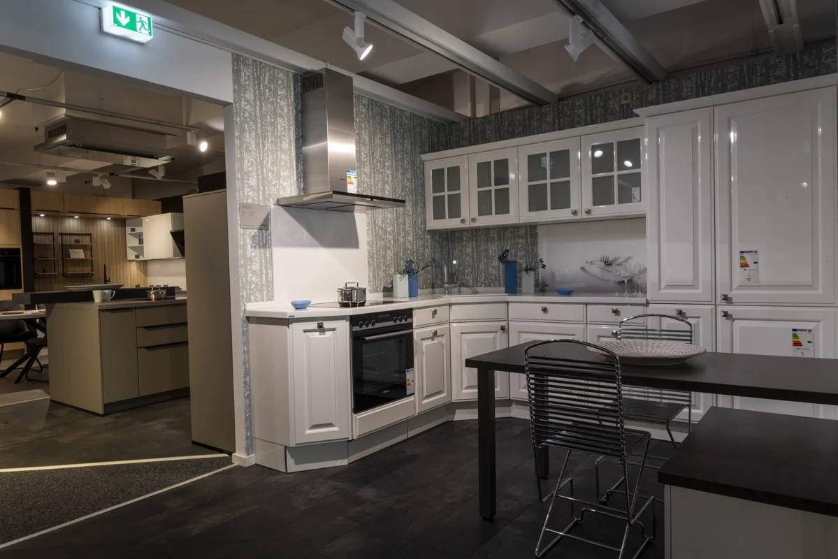 Harbeke • Moderne weiße Küche mit Kochstelle und Essbereich.